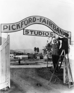 Mary Pickford and Douglas Fairbanks posing for a publicity shot in front of their new studio in 1922
